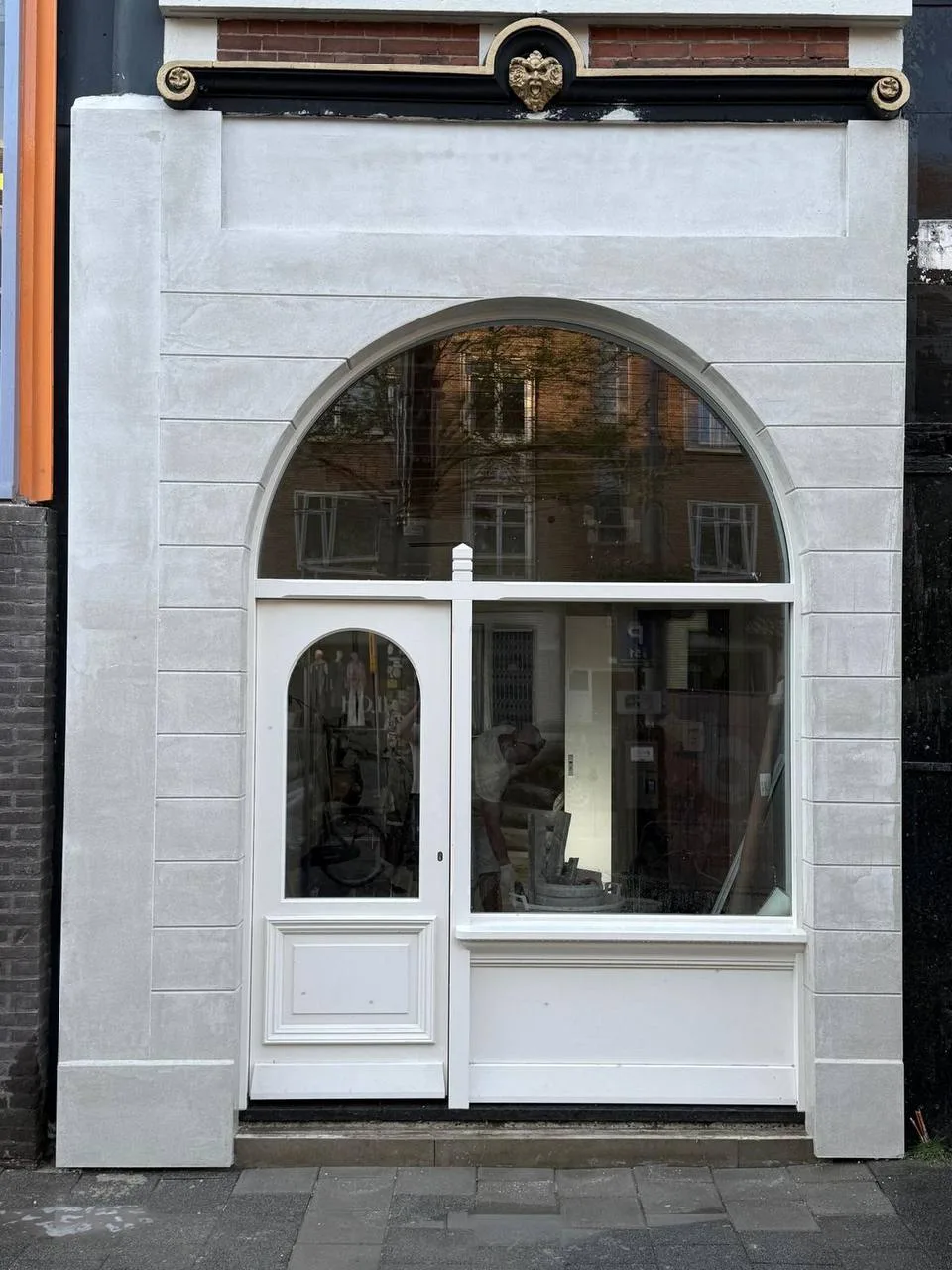 Dezelfde winkelpui na het stucwerk, glad gestuukt rond de boog met witte kozijnen