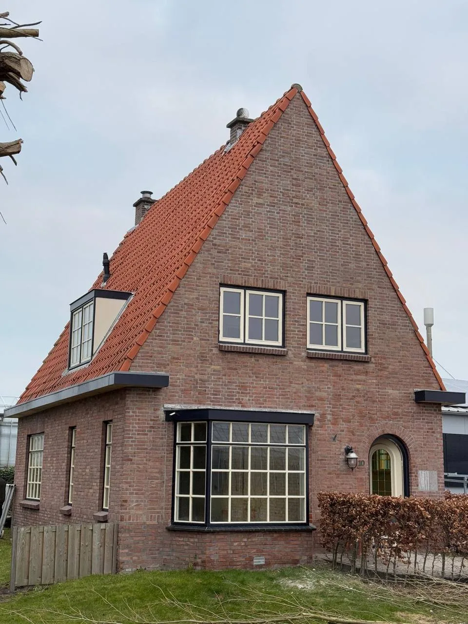 Woning met een oud rood pannendak en een dakkapel, voor de vervanging