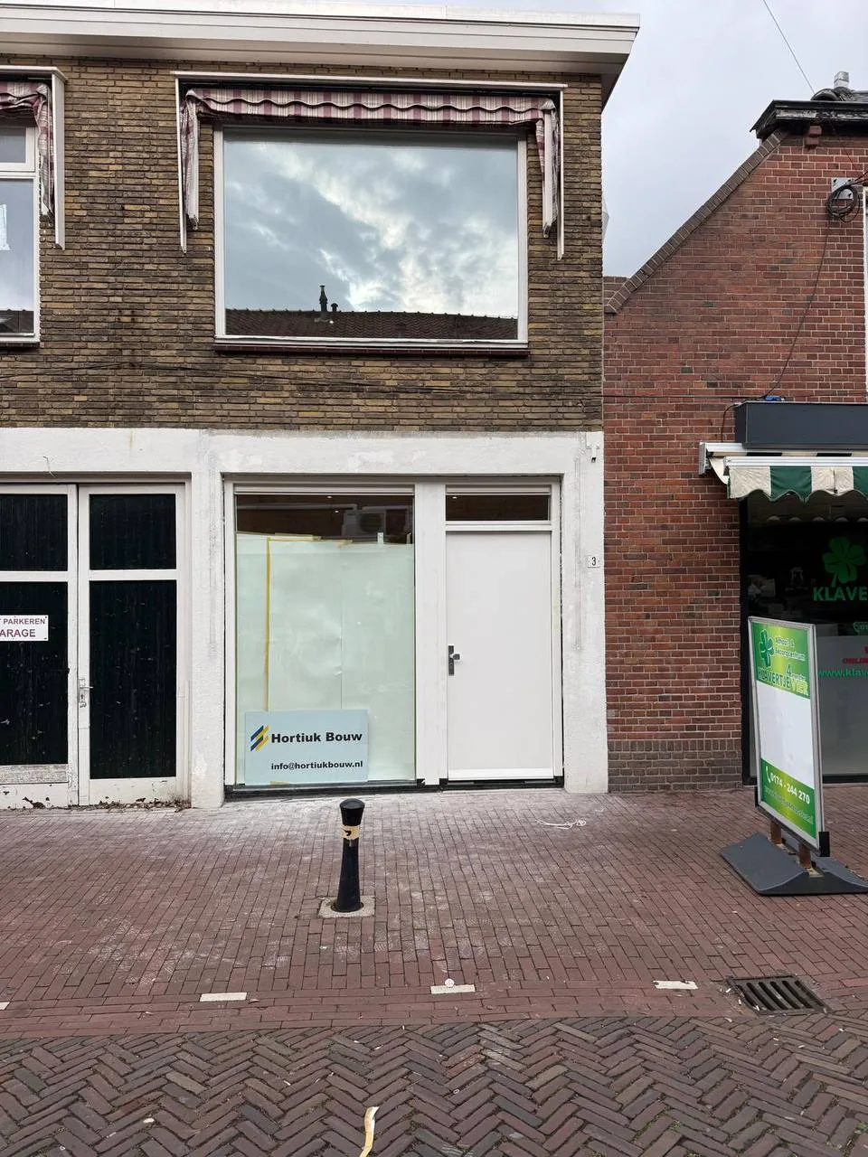 Dezelfde voorpui vlak na het plaatsen, met een bord van Hortiuk Bouw in het raam