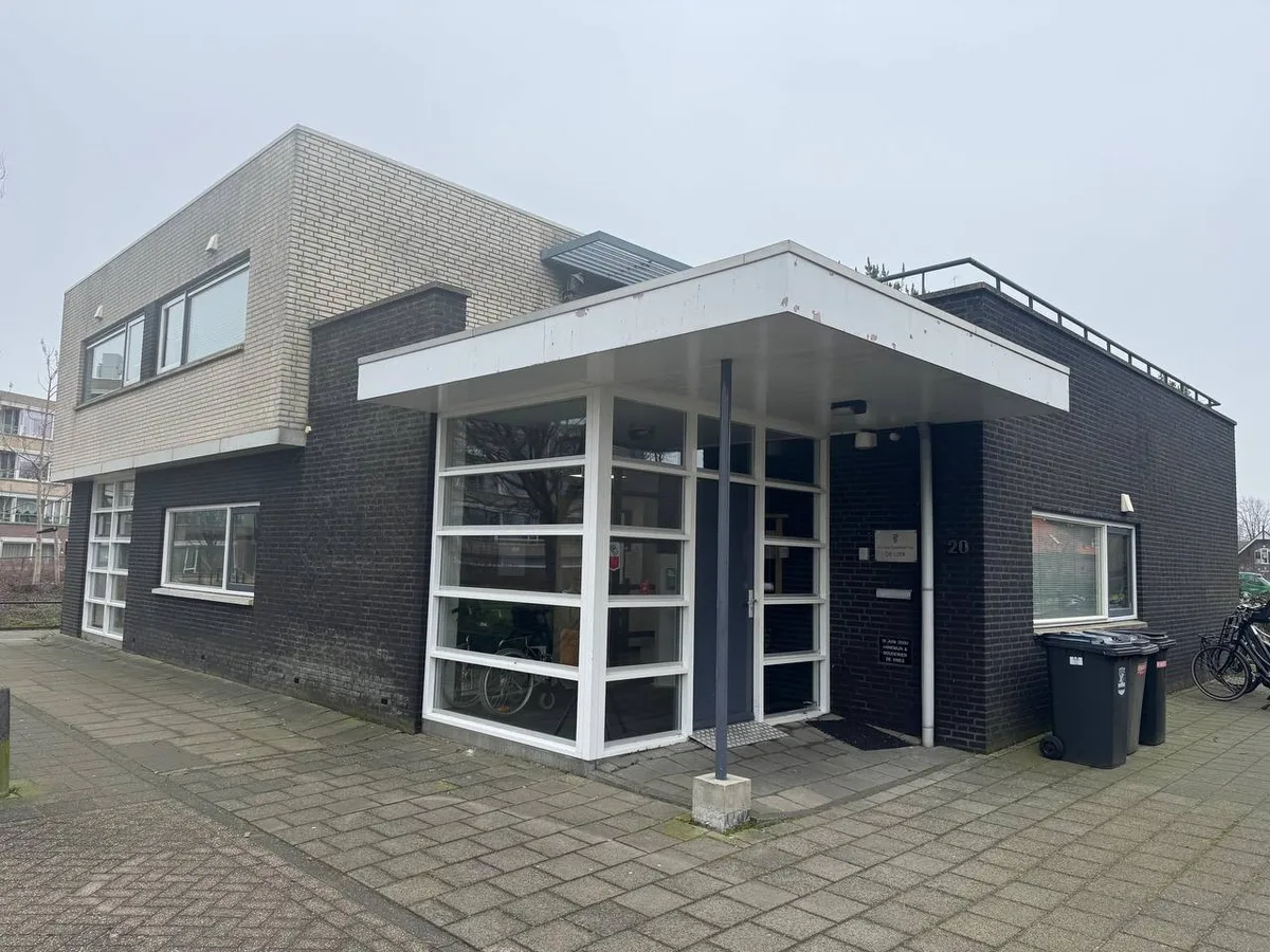 Praktijkpand voor het schilderwerk: donkere baksteen, witte kozijnen en een verweerde witte luifel