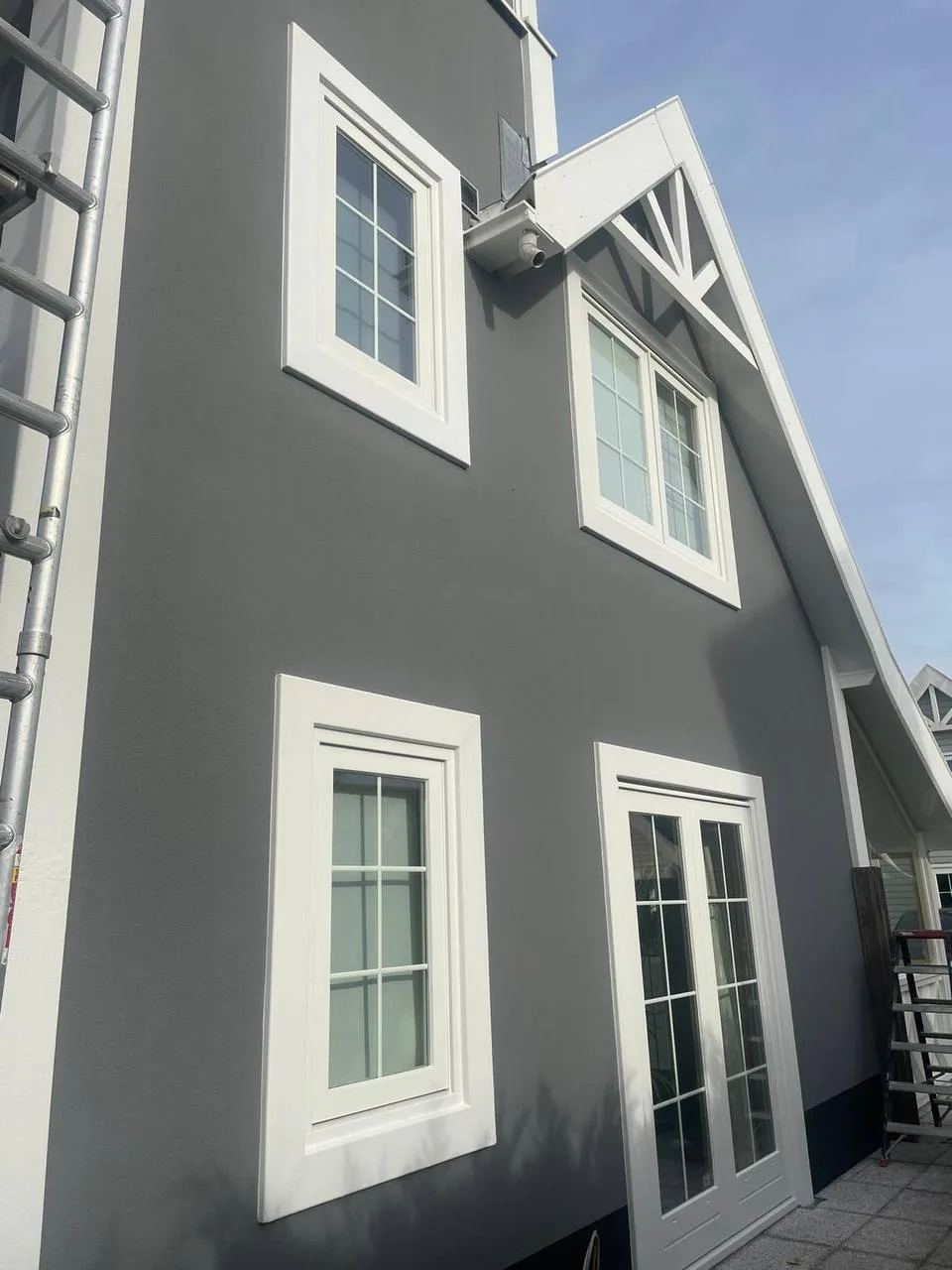 Woning met een grijs geschilderde gevel en witte kozijnen